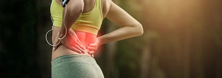 Concussion Irvine CA Low Back Pain A person holding their lower back. Their back is highlighted red.