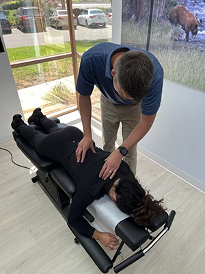Chiropractor Nicholas Hoy adjusting a patients back.