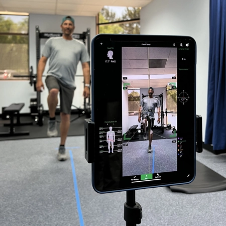 A patient doing a posture assessment. They are holding on leg up.